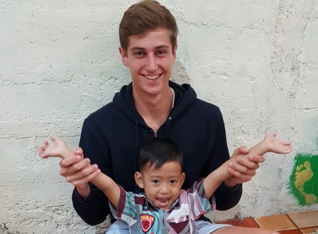 Image of Luca and child on Society Travel Grant funded trip to Bali